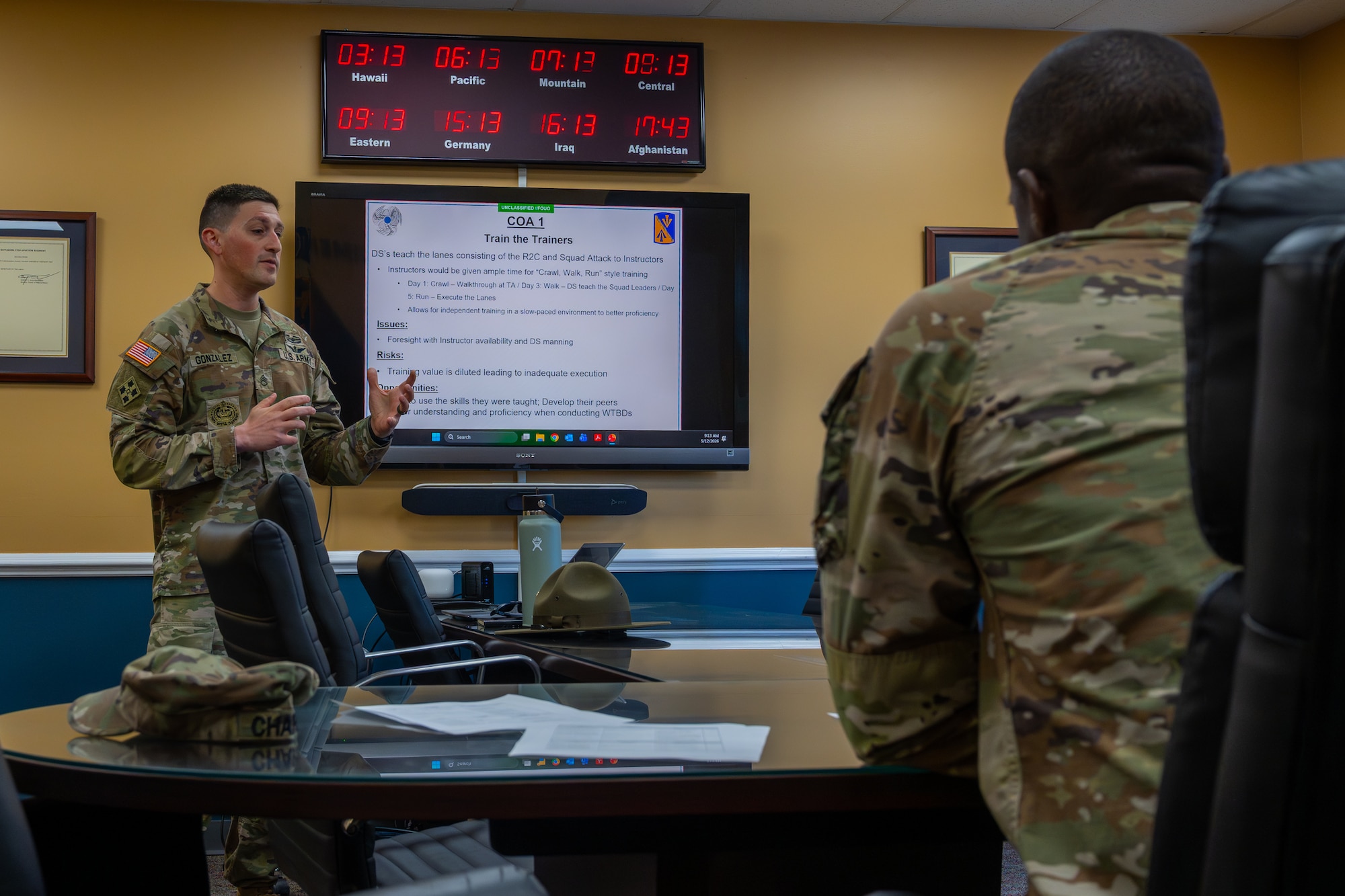 A man stands in front of a presentation while talking.