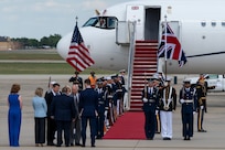 King Charles III greets attendees during a departure ceremony while the Joint Service Color Guard stand at attention.