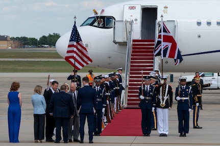 King Charles III greets attendees during a departure ceremony while the Joint Service Color Guard stand at attention.