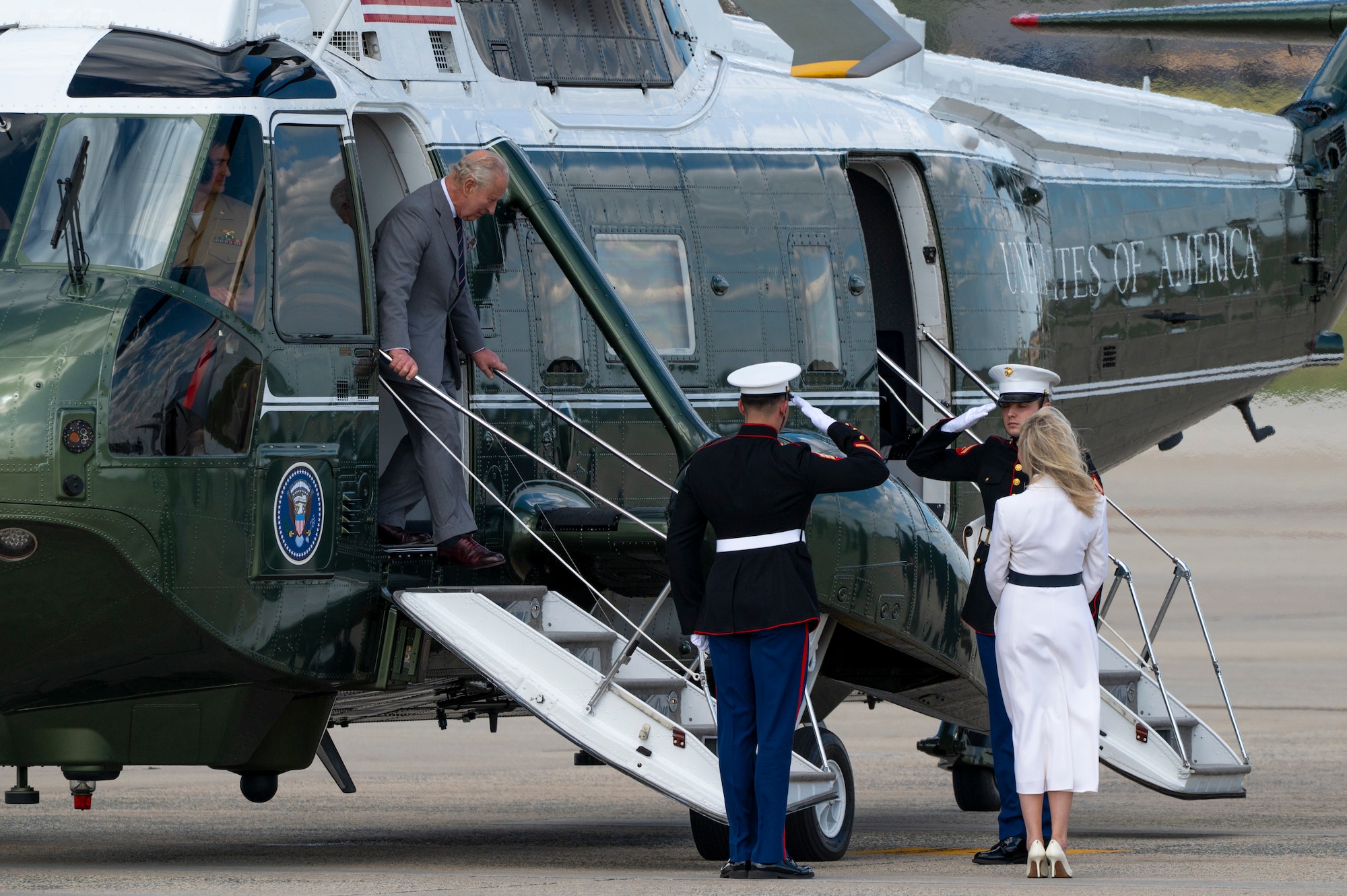 King Charles III exits a helicopter during a departure ceremony.
