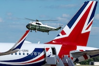 A helicopter transports King Charles III to a departure ceremony.