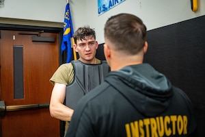U.S. Air Force Senior Airman Lance Kuhn, 99th Security Forces Squadron patrolman at Nellis Air Force Base, Nev., receives feedback from Tech. Sgt. Michael Lex, 421st Combat Training Squadron Phoenix Raven Qualification Course noncommissioned officer in charge, after his “Red Man” evaluation during the PRQC at Joint Base McGuire-Dix-Lakehurst, N.J., April 22, 2026.