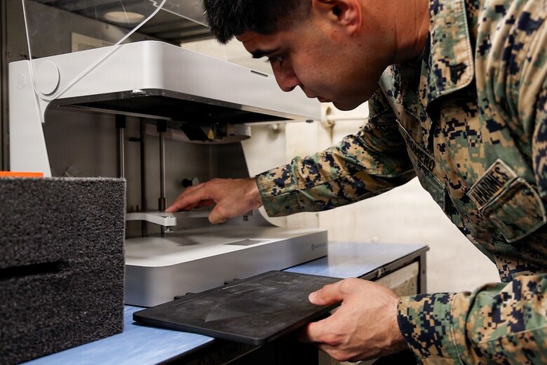 A Marine prepares a 3D printer