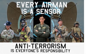 Five U.S. Airmen stand in front of two satellites.