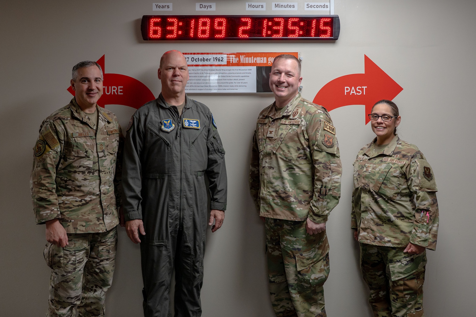 Gen. Davis, Col. Voorhies, Chief Master Sgt. Aiello, and Chief Master Sgt. Thrasher-Stallard stand in from of the "First Ace in the Hole" clock.