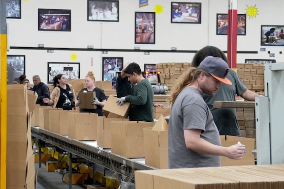 People putting together ration kits in a warehouse.