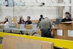 People putting together ration kits in a warehouse.