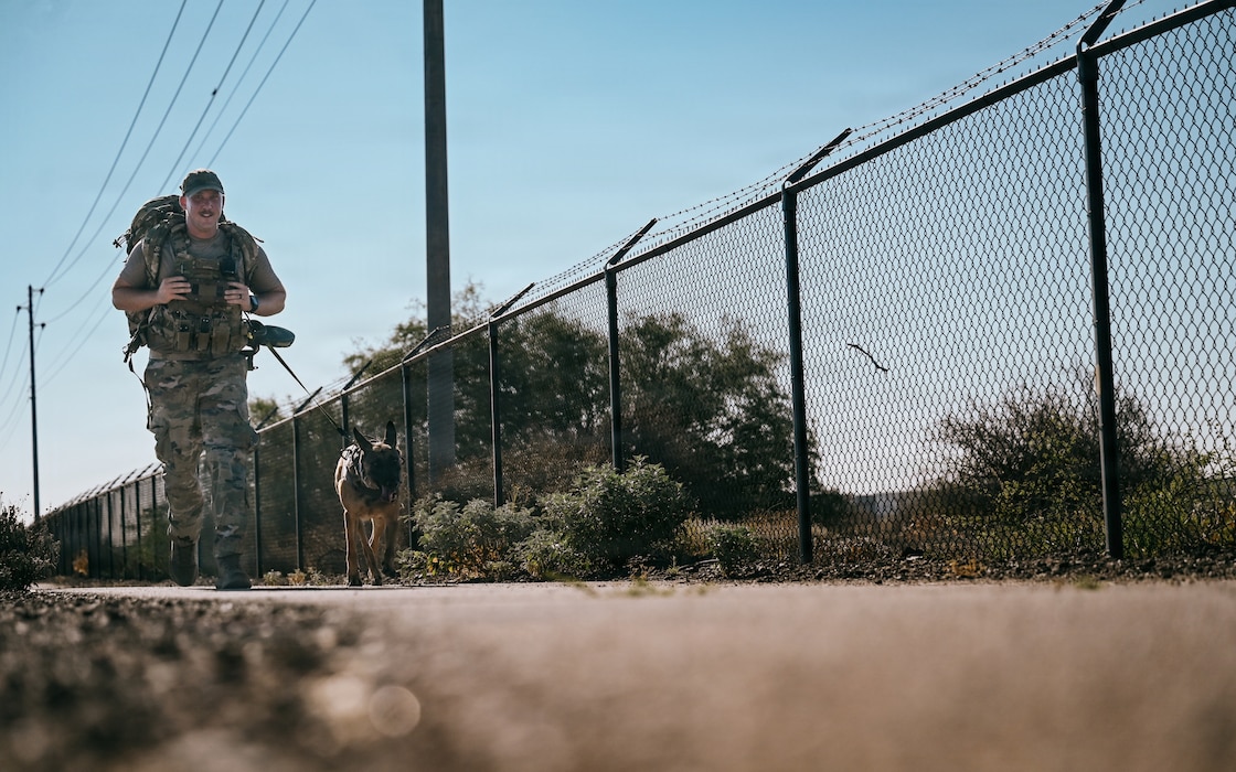 U.S. Air Force Staff Sgt. Russel Postmus, 56th Security Forces Squadron military working dog handler, runs with military working dog Bboa during a memorial 5K for 2026 Police Week at Luke Air Force Base, Arizona, May 11, 2026. Airmen demonstrated unrivaled warrior ethos during the 5K to honor law enforcement officers who made the ultimate sacrifice in service to their communities. (U.S. Air Force photo by Senior Airman Katelynn Jackson)