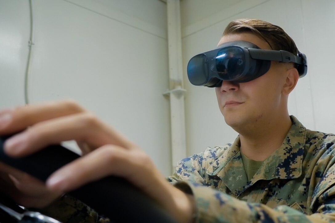 Marine wearing VR goggles using ACV simulator aboard ship