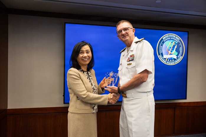 Vice Adm. Johnny Wolfe Jr., director for Portfolio Acquisition Executive (PAE) Strategic Systems Programs (SSP), presents Ms. Kelly Lee, the director of the plans and programs division at PAE SSP and a member of the Senior Executive Service, with the Director’s Award at the biannual Steering Task Group (STG) meeting in Washington D.C., on May 13, 2026. 

With more than 35 years of service to the program, Ms. Lee has provided technical expertise and a high-level understanding of weapon system processes that have contributed to critical developments within the Trident II D5 Life Extension (D5LE) program. The Director’s Awards are presented annually with the purpose of recognizing the personal contributions of the PAE SSP government team. To date, only 50 people have received the Director’s Award, including this year’s recipients. Wolfe also presented this year’s Fleet Ballistic Missile Lifetime Achievement Awards at the STG meeting.