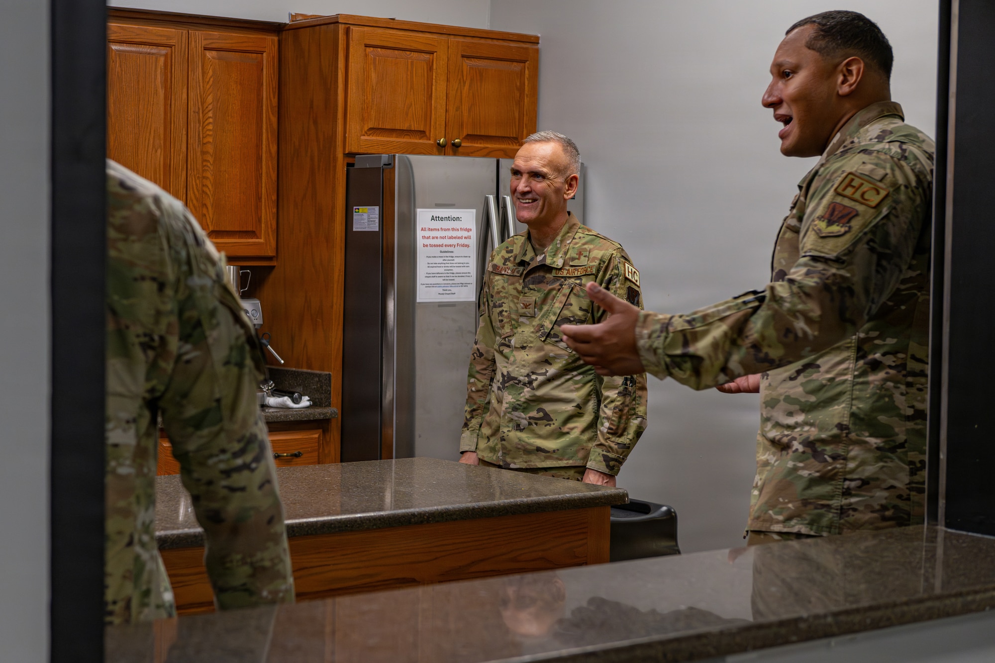 Military members in a kitchen talking.