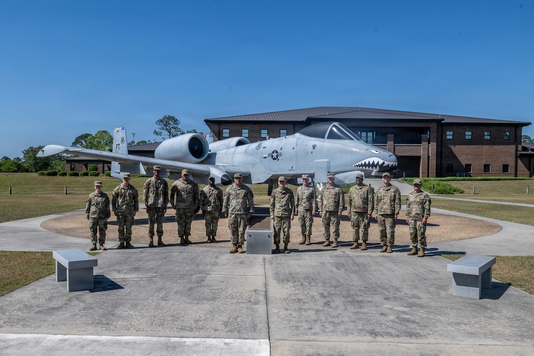A group of military members standing in front of a A-10 Thunderbolt II.