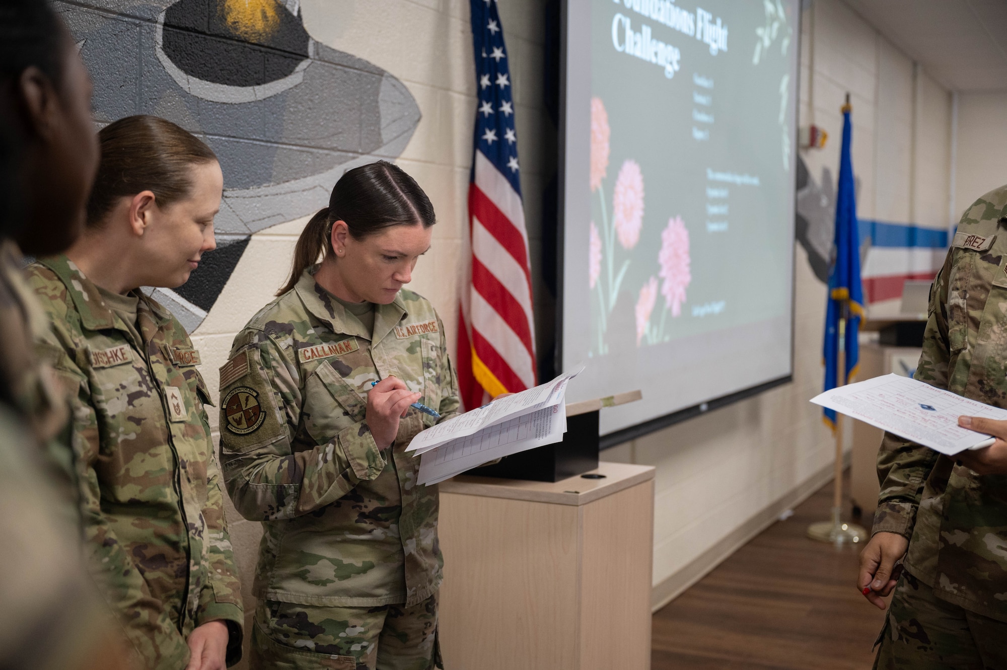 A U.S. Airman holds papers with her coworker looking on.
