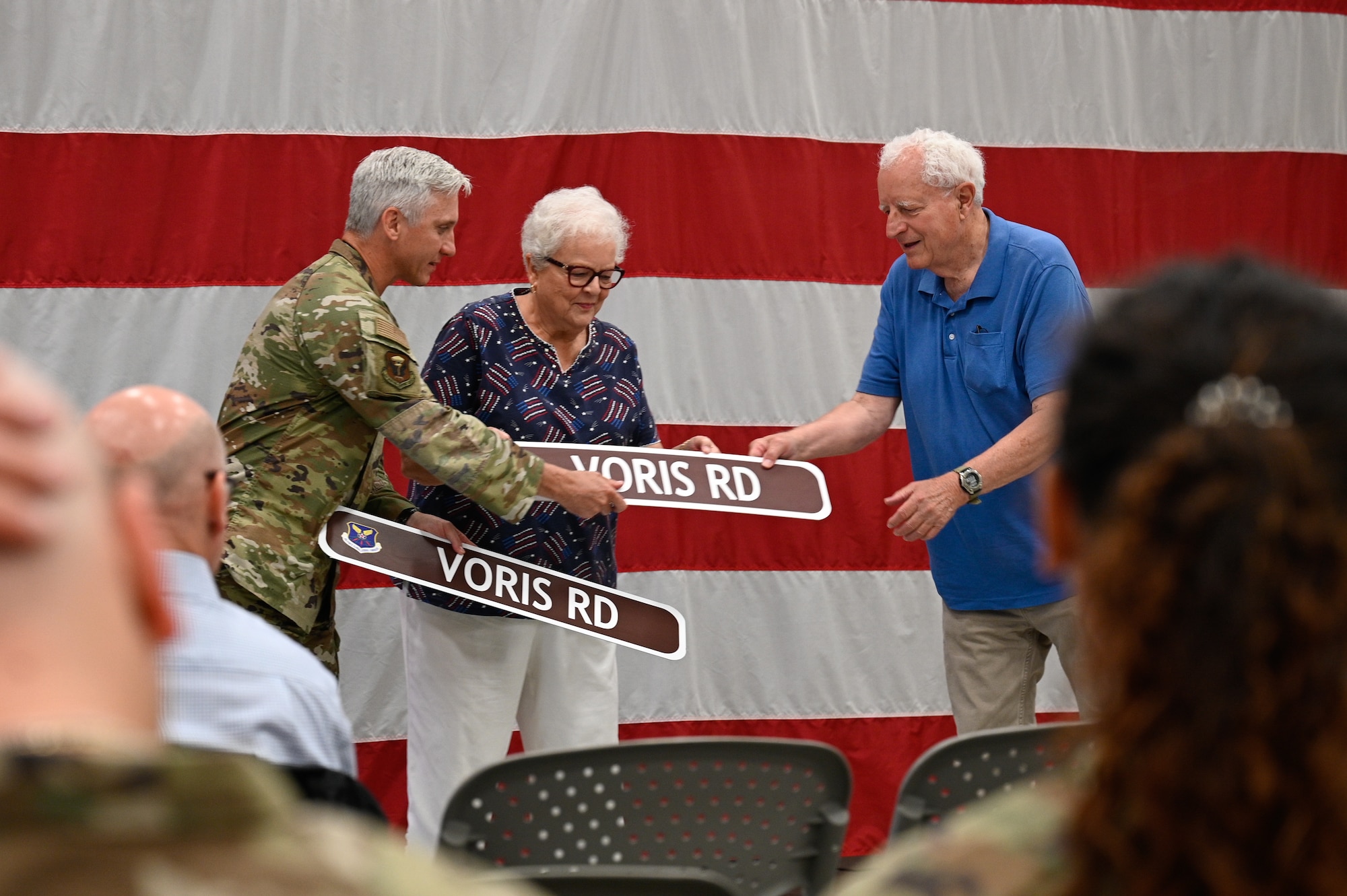 The 509th Mission Support Group commander presents commemorative street signs to 1st Lt. Russel Voris’s siblings, Judy and Paul, during a road dedication ceremony at Whiteman Air Force Base, Missouri, May 18, 2026.