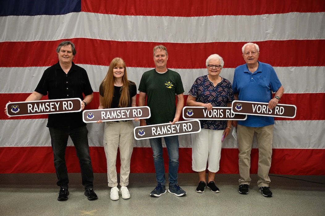 U.S. Air Force Maj. Milton Ramsey’s children, Kathleen, Gary and Ron, and 1st Lt. Russel Voris’s siblings, Judy and Paul, pose for a photo with their commemorative street signs during a road dedication ceremony at Whiteman Air Force Base, Missouri, May 18, 2026.