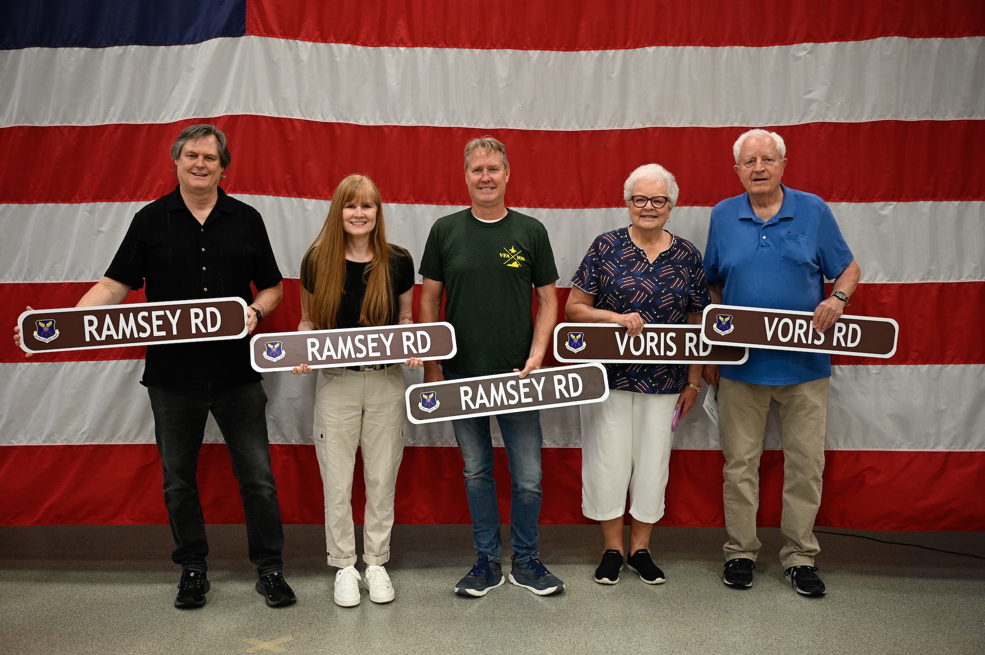 U.S. Air Force Maj. Milton Ramsey’s children, Kathleen, Gary and Ron, and 1st Lt. Russel Voris’s siblings, Judy and Paul, pose for a photo with their commemorative street signs during a road dedication ceremony at Whiteman Air Force Base, Missouri, May 18, 2026.