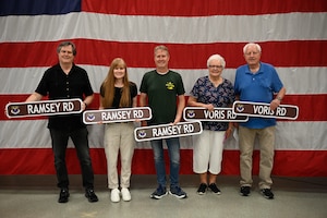 U.S. Air Force Maj. Milton Ramsey’s children, Kathleen, Gary and Ron, and 1st Lt. Russel Voris’s siblings, Judy and Paul, pose for a photo with their commemorative street signs during a road dedication ceremony at Whiteman Air Force Base, Missouri, May 18, 2026.