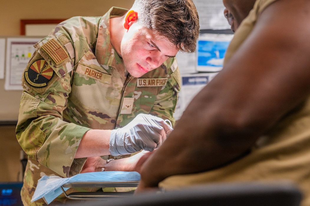 U.S. Air Force Airman Seneca Parker, Luke Medical Group Healthcare Operations Squadron family health medical technician, trains to draw blood during Nurse and Tech Week at Luke Air Force Base, Arizona, May 13, 2026.