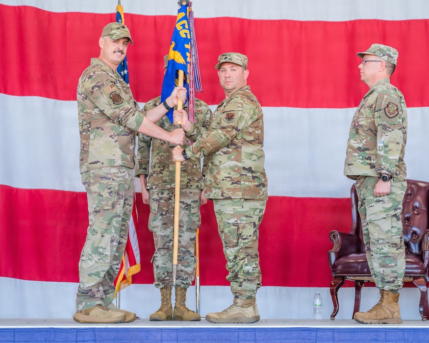 U.S. Air Force Lt. Col. Steven Rohmiller, Air Combat Command Training Center commander, passes the guidon to Lt. Col. Shane Kinsman, incoming Air Combat Command Training Support Squadron Detachment 9 commander, at Luke Air Force Base, Arizona, May 14, 2026