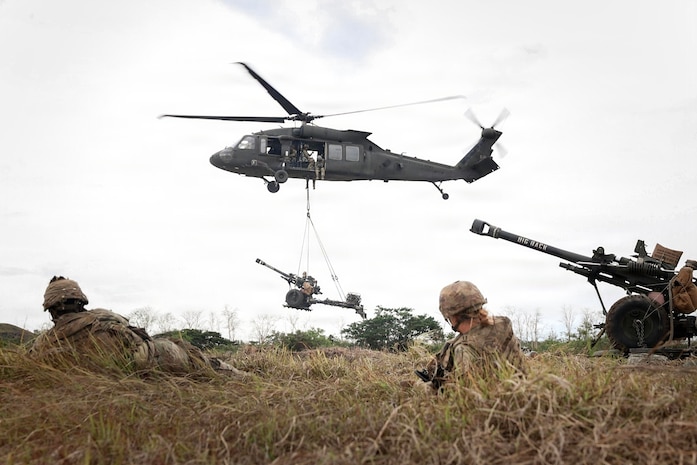 A U.S. Army UH-60 Black Hawk helicopter assigned to Task Force Saber, 25th Combat Aviation Brigade, prepares to land a sling loaded M119 Howitzer assigned to the 3rd Battalion, 7th Field Artillery Regiment, 25th Infantry Division Artillery (DIVARTY), 25th Infantry Division, during the Joint Pacific Readiness Center Exportable Exercise at Fort Magsaysay, Nueva Ecija, Philippines, May 16, 2026.