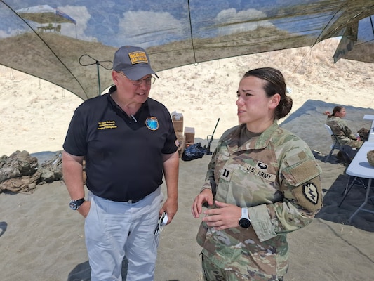 U.S. Indo-Pacific J7 Pacific Multi-Domain Training and Experimentation Capability Range Lead Dave Bednarcik and U.S. Army 25th Infantry Division Artillery Fire Control Officer, Capt. Pheobe Lee, discuss maritime target staging for the next day’s Balikatan 2026 counter-landing live-fire exercise at La Paz Sand Dunes, Laoag City, Philippines, May 3, 2026.
