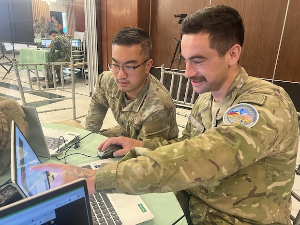 U.S. Army Spc. Justin Xu, 1st Multi-Domain Effects Battalion, and New Zealand Army Lance Cpl. Liam Van Der Mespel, 1st Command Support Regiment, analyze data for Blue Team 6 during the Balikatan 2026 cyber defense exercise at Camp Aguinaldo, Philippines, April 29, 2026.