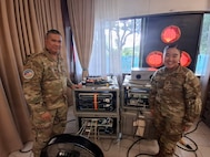 U.S. Air Force Senior Master Sgt. Mark Savares, 293rd Combat Communications Squadron, Guam Air National Guard and U.S. Air Force Capt. Yareem Lee, Pacific Air Forces Headquarters Offensive Cyber Operations, check on the Deployable Cyber Range during the Balikatan 2026 cyber defense exercise at Camp Aguinaldo, Philippines, May 5, 2026.
