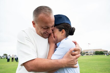 Airman Bryanna Garcia is embraced by her father Jacob Garcia after graduating from the Basic Military Training, May 7, 2026. Airman Garcia’s father served as a Partner Nation Instructor at the at the Inter-American Air Forces Academy in 2006 for two years. Garcia was born in the U.S. and was inspired to follow in her father’s footsteps working in aviation maintenance. (U.S. Air Force photo by Vanessa R. Adame)