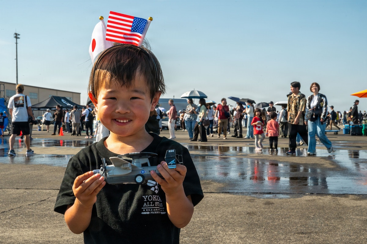 A child posing with a festival toy