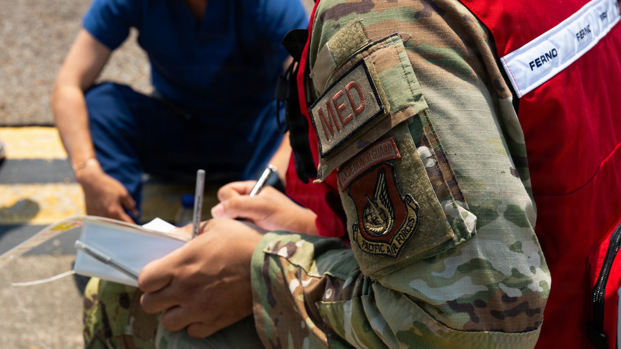 Medical personnel wearing OCP camouflage uniform with a red medical vest fills out casualty information during a major accident response exercise as part of exercise Mustang Rodeo 26-2 at Osan Air Base, Republic of Korea, May 14, 2026.