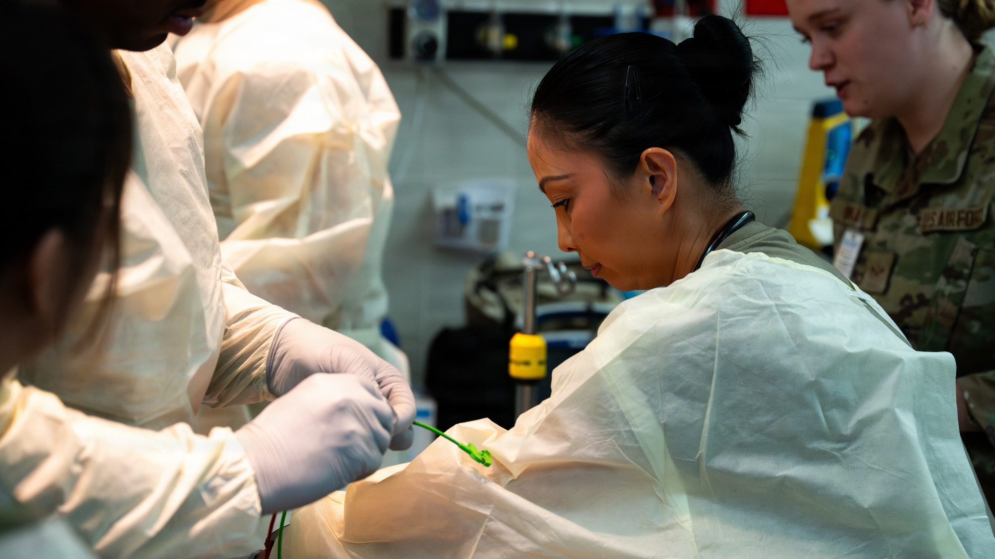 Military members in scrubs and gloves evaluate simulated victims during a major accident response exercise as part of exercise Mustang Rodeo 26-2