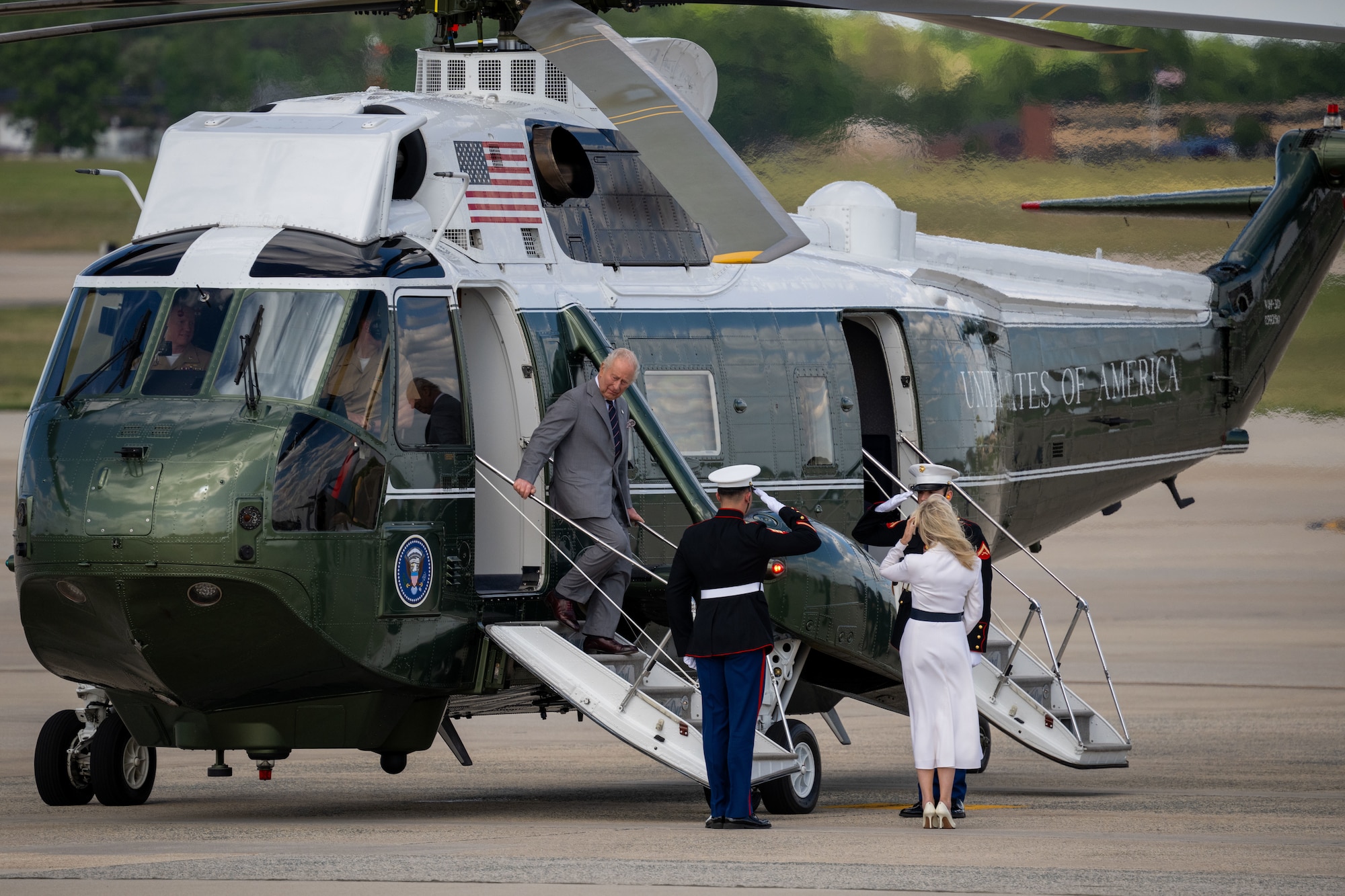 King Charles III exits a helicopter during a departure ceremony.