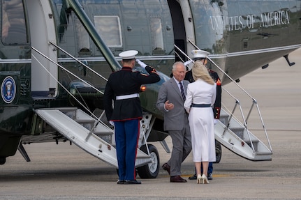 King Charles III exits a helicopter during a departure ceremony.