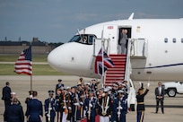 The Joint Service Color Guard and cordon present arms during a departure ceremony, while King Charles III waves goodbye.