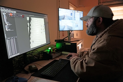 Photo shows man looking at computer screen
