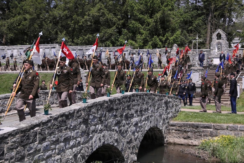 U.S. Army Soldiers carry unit guidons across a stone footbridge following the 28th Infantry Division’s annual memorial service May 17, 2026, in Boalsburg, Pennsylvania. The memorial service honored fallen Soldiers of the 28th Infantry Division and recognized Gold Star families at the 28th Infantry Division Shrine on the grounds of the Pennsylvania Military Museum. (U.S. Army National Guard photo by Staff Sgt. Kenneth Shirk)