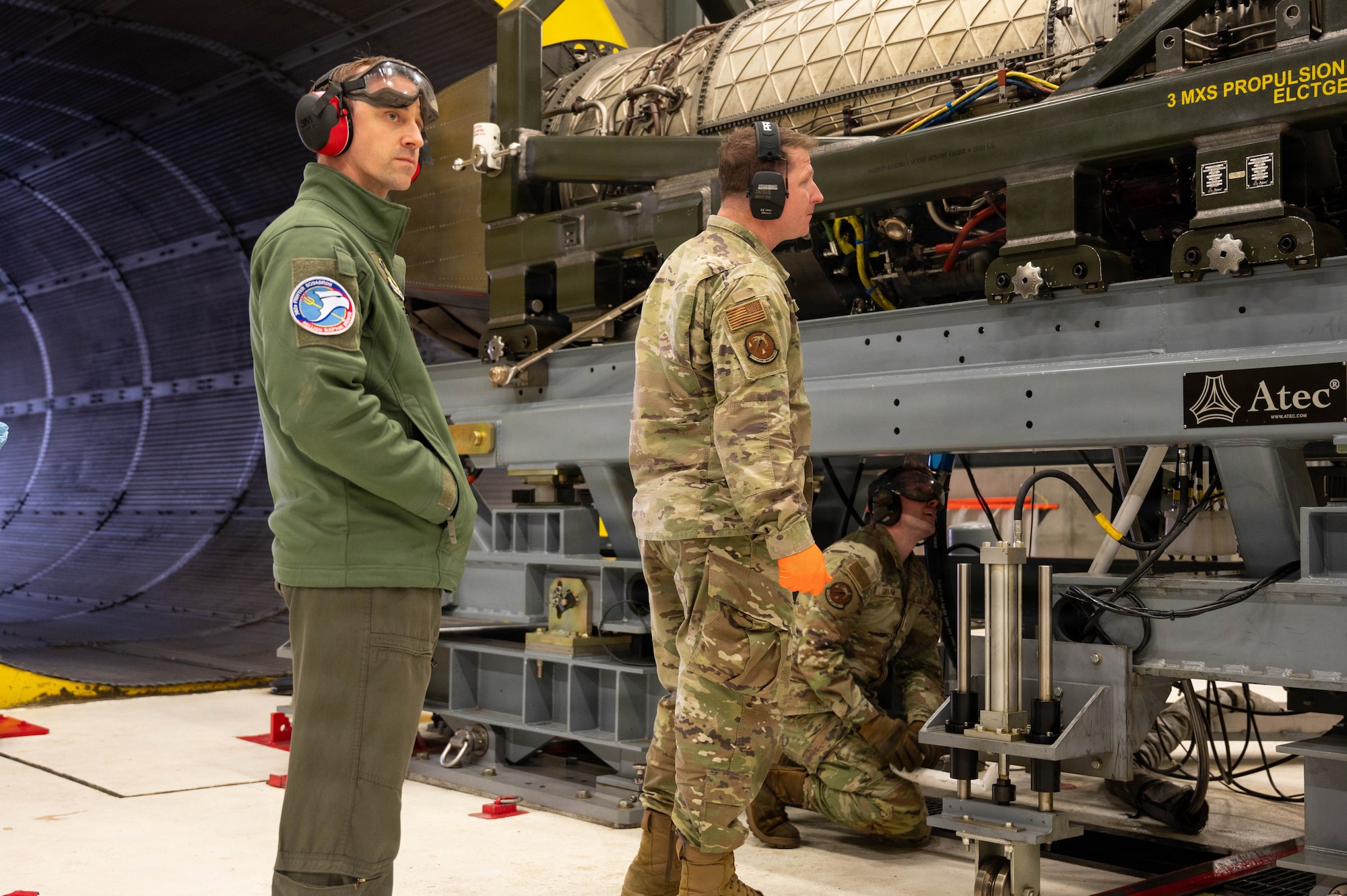 Two Airmen inspect an aircraft engine