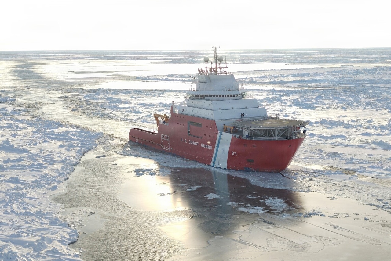 A large ship sails through icy water.