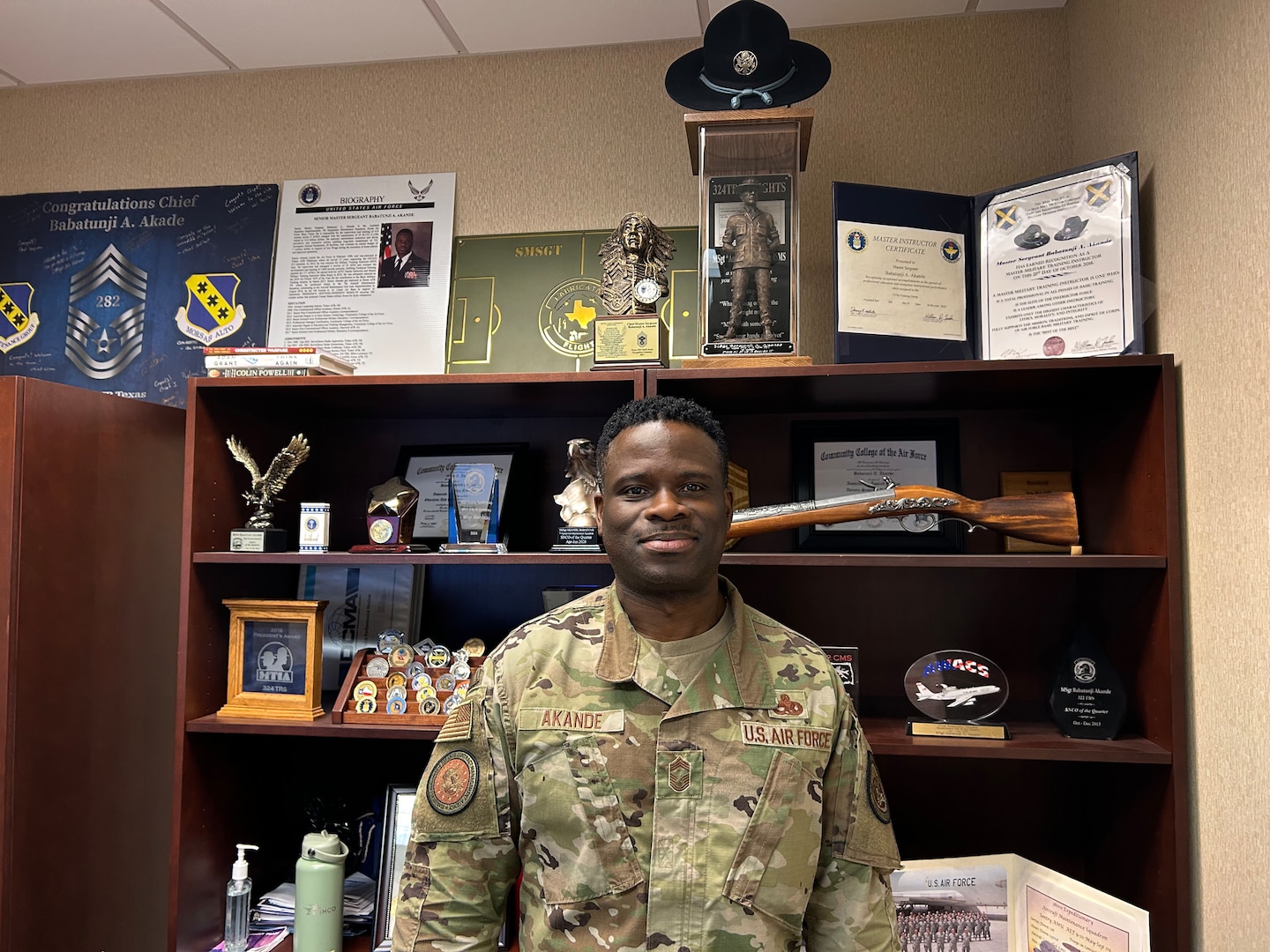 Smiling man wears a camouflaged military uniform