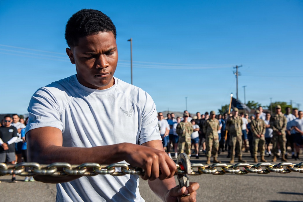 Airman hangs tie down hooks during memorial ceremony