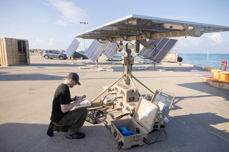 A contractor checks equipment during a military exercise.