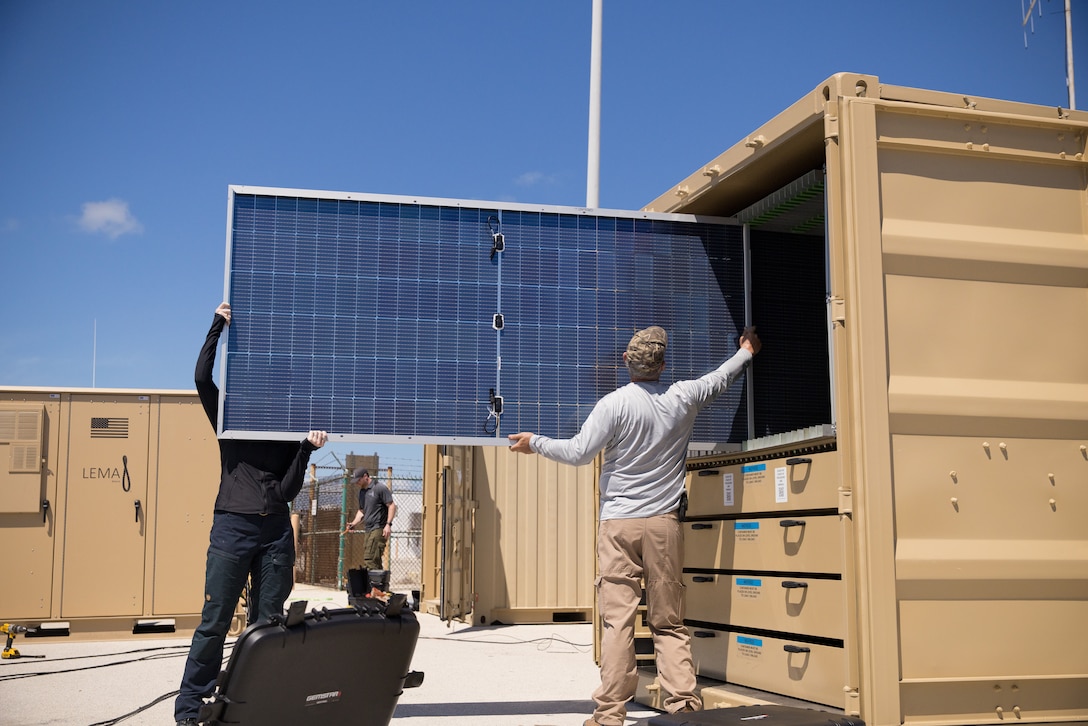 Two men store energy panels during a U.S. military exercise.