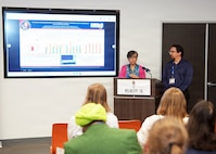 SAN ANTONIO – (May 18, 2026) – Research scientists Tarea Burton and Andres Martinez Murillo assigned to Naval Medical Research Unit (NAMRU) San Antonio’s Combat Casualty Care and Operational Medicine directorate, briefed research on a portable ozone sterilizer at the Defense Health Agency’s annual Promote Professional Engagement amongst Military Laboratories (ProPEL) Science Symposium held at the VelocityTX Innovation Center. The event brought together military medical professionals, researchers, students, and academic partners to explore the latest in defense health innovation.  Attendees at ProPEL heard from several San Antonio Centers of Excellence to include research presentations on Battlefield/Point of Injury, Prolonged Field Care/Early Interventions, and Integrated Rehabilitation and Human Performance. Collaborating and working alongside a wide range of research and development partners keeps Navy Medicine Research & Development (NMR&D) abreast of best practices and advances in medical knowledge. NAMRU San Antonio, part of NMR&D conducts gap-driven combat casualty care, craniofacial, and directed energy research in support of Navy, Marine Corps and joint U.S. warfighter health readiness and lethality while engaged in routine and expeditionary operations. (Photo by Burrell Parmer, NAMRU San Antonio Public Affairs/Released)