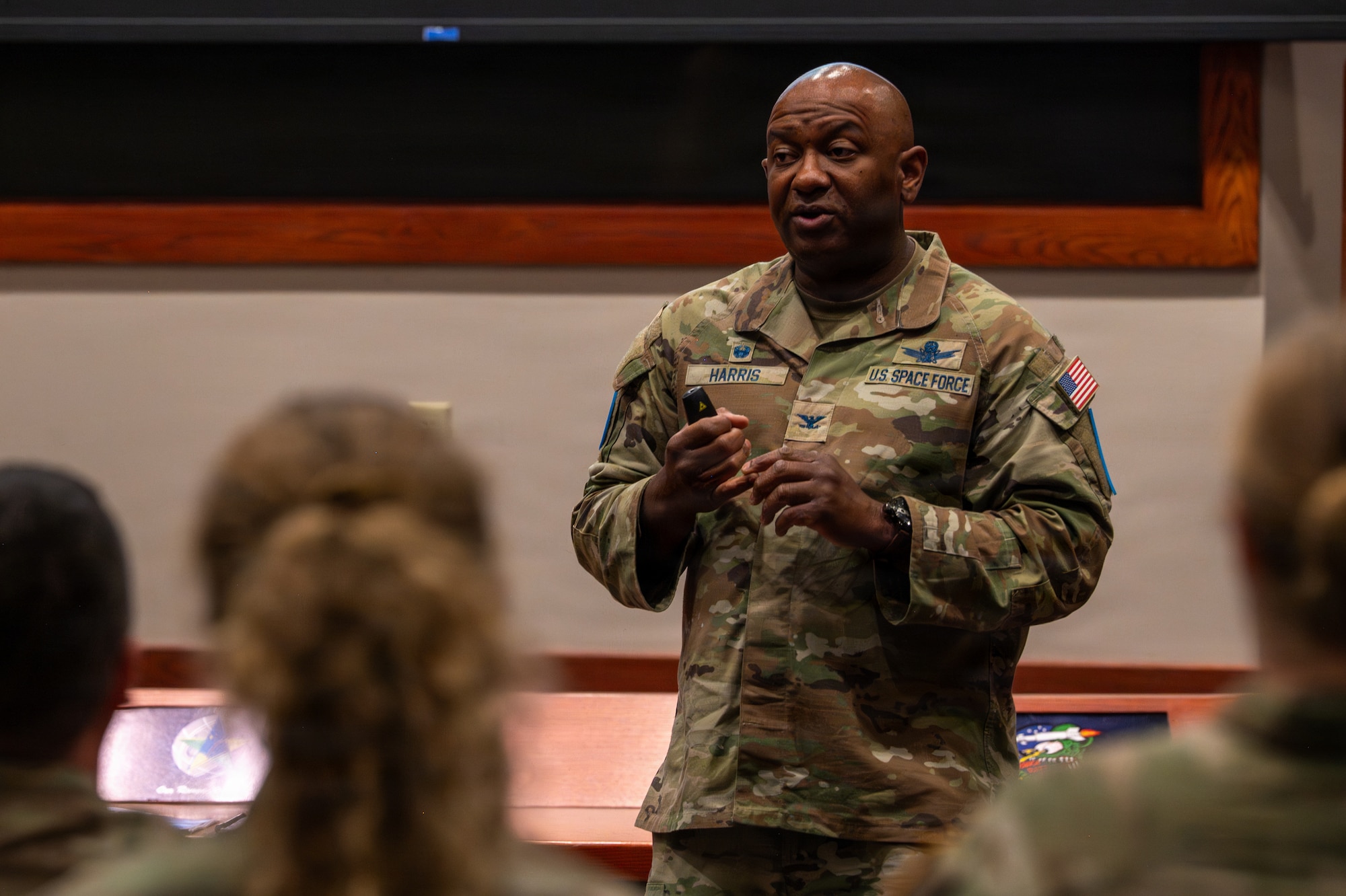 A person stands and speaks to people sitting in an auditorium.