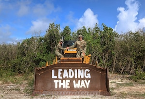 Two U.S. Air Force Airmen assigned to the 240th Civil Engineer Flight, Colorado Air National Guard pose on top of heavy machinery while deployed to the U.S. Indo-Pacific region during 2025. The 240 CEF completed a six-month deployment throughout various locations in the region, where they planned and rehabilitated key infrastructure. (courtesy photo)