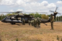 U.S. Army Cpl. Jonathan Zyk, a crew chief assigned to the 3rd Mobile Brigade, 25th Infantry Division, guides Japan Ground Self-Defense Force soldiers assigned to the 2nd Infantry Regiment, 12th Brigade (Air Assault), toward a UH-60 Black Hawk helicopter to execute a multinational air assault exercise during the Joint Pacific Readiness Center Exportable Exercise at Colonel Ernesto Ravina Air Base in Capas, Tarlac, Philippines, May 17, 2026.