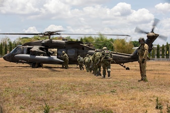 U.S. Army Cpl. Jonathan Zyk, a crew chief assigned to the 3rd Mobile Brigade, 25th Infantry Division, guides Japan Ground Self-Defense Force soldiers assigned to the 2nd Infantry Regiment, 12th Brigade (Air Assault), toward a UH-60 Black Hawk helicopter to execute a multinational air assault exercise during the Joint Pacific Readiness Center Exportable Exercise at Colonel Ernesto Ravina Air Base in Capas, Tarlac, Philippines, May 17, 2026.