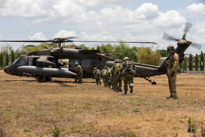 U.S. Army Cpl. Jonathan Zyk, a crew chief assigned to the 3rd Mobile Brigade, 25th Infantry Division, guides Japan Ground Self-Defense Force soldiers assigned to the 2nd Infantry Regiment, 12th Brigade (Air Assault), toward a UH-60 Black Hawk helicopter to execute a multinational air assault exercise during the Joint Pacific Readiness Center Exportable Exercise at Colonel Ernesto Ravina Air Base in Capas, Tarlac, Philippines, May 17, 2026.