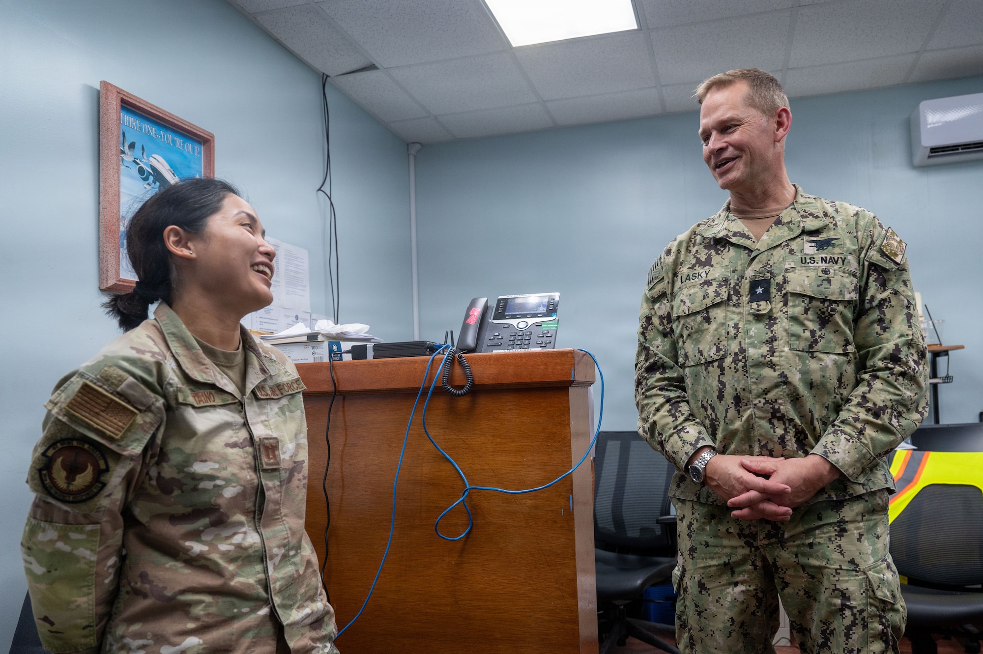 U.S. Navy Rear Adm. Josh Lasky, commander of Joint Task Force - Micronesia, right, speaks with U.S. Air Force Capt. Lyza Taino, 36th Contingency Response Squadron air mobility liaison officer