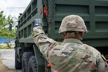 U.S. Army Reservist, Sgt. Vicente Baleto assigned to the 797th Engineer Vertical Construction Company, 9th Mission Support Command, Honolulu, Hawaii, guides a vehicle delivering safe drinking water to Saipan residents as part of Typhoon Sinlaku recovery efforts in Saipan, Commonwealth of the Northern Mariana Islands, May 17, 2026.